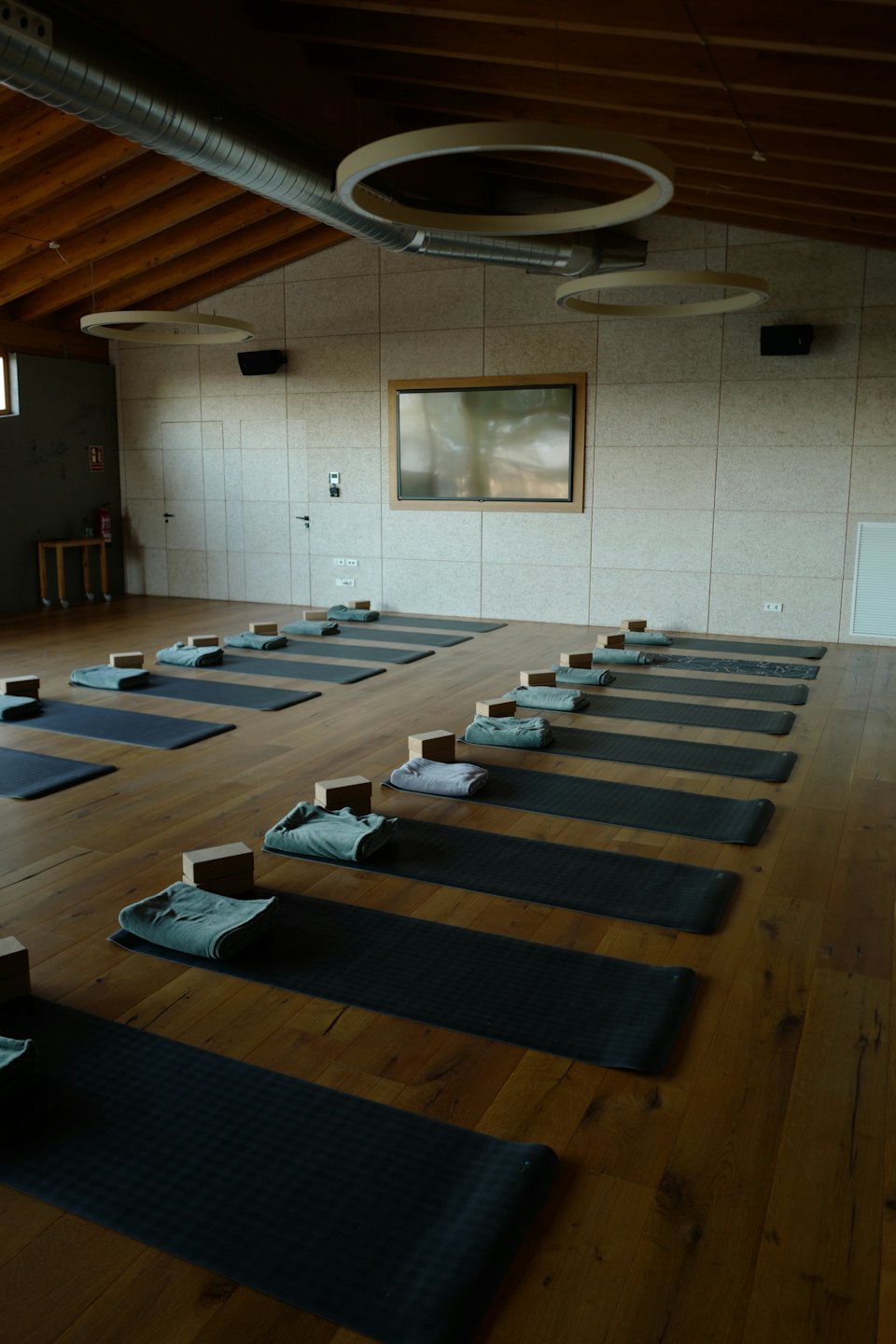 Sala yoga con tappetini, blocchi e asciugamani disposti ordinatamente.