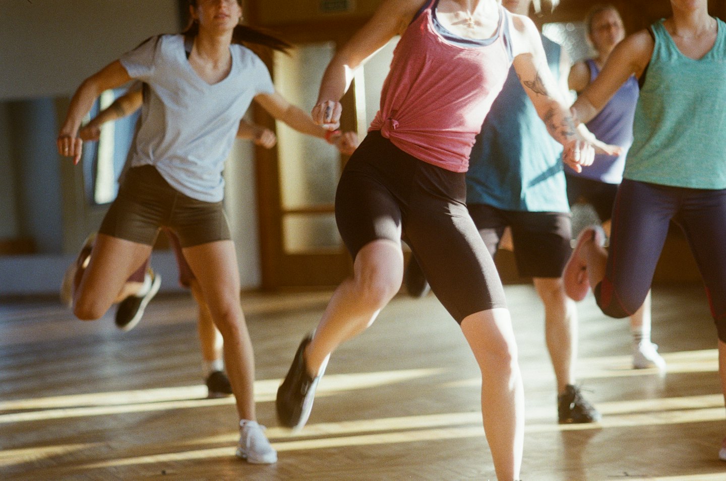 Persone che si allenano insieme in una luminosa lezione di fitness.